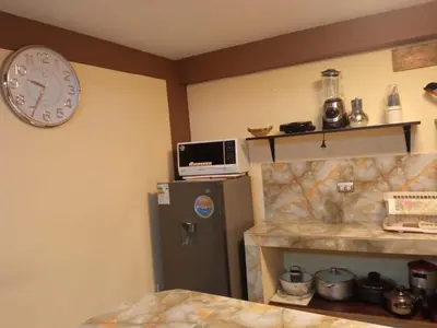 a room with a clock on the wall and a refrigerator at La Casita de Gabriel in Cusco