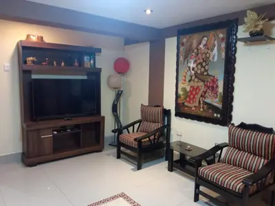 a living room with two chairs and a flat screen tv at La Casita de Gabriel in Cusco
