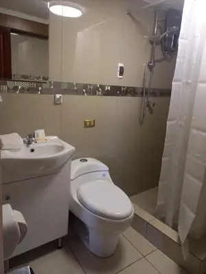 a bathroom with a white toilet and a sink at La Casita de Gabriel in Cusco
