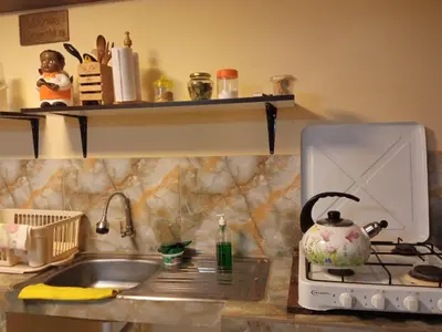 a kitchen with a sink and a stove with a tea kettle at La Casita de Gabriel in Cusco