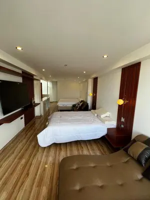 a hotel room with two beds and a flat screen tv at Hotel SOGU TOWER in Ayacucho