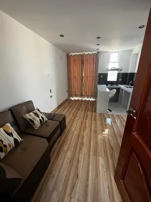 a living room with a couch and a kitchen at Hotel SOGU TOWER in Ayacucho