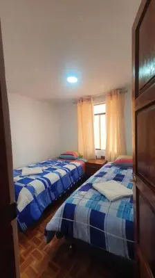 a bedroom with two beds and a window at Hospedaje Mary House - En el corazón del Cusco in Cusco