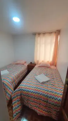 a bedroom with two beds with a laptop on it at Hospedaje Mary House - En el corazón del Cusco in Cusco