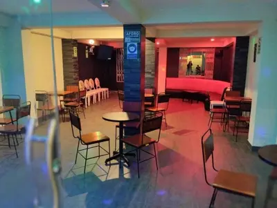 a room with tables and chairs in a building at Brianny Hotel in Churín