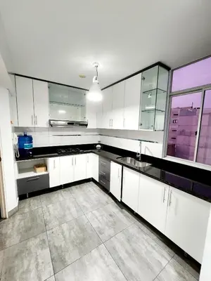 a kitchen with white cabinets and a large window at Duplex MyM in Lima