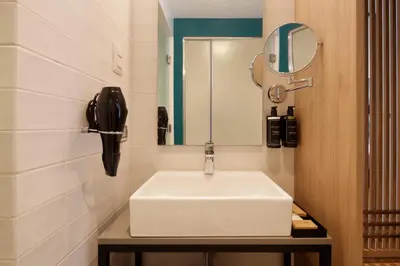 a bathroom with a white sink and a telephone at Ikonik Miraflores in Lima
