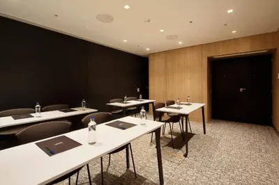 a conference room with tables and chairs and a black wall at Ikonik Miraflores in Lima