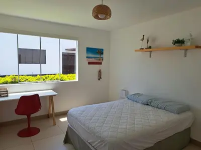 a bedroom with a bed and a desk and a window at Alquilo casa de playa Condominio Playa Azul cerca de Asia in Cerro Azul