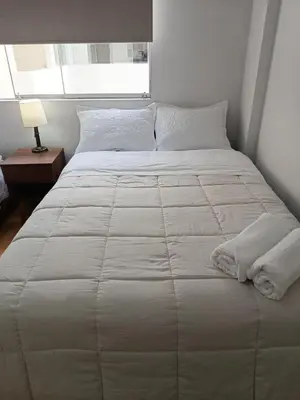 a large white bed in a room with a window at Miraflores View in Lima