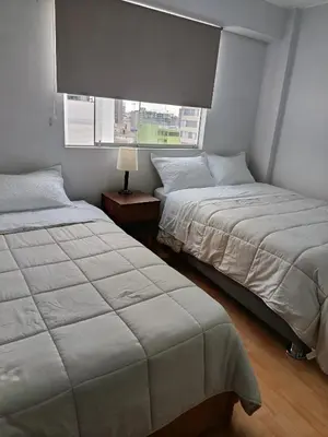 two beds in a bedroom with a window at Miraflores View in Lima