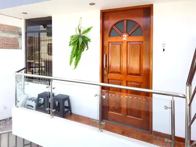 a house with a balcony with a wooden door at Hospedaje Celerina & Elio in Lima