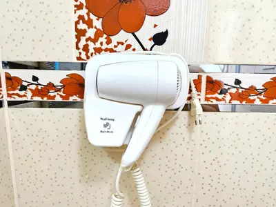 a hair dryer hanging on the wall in a bathroom at Hospedaje Celerina & Elio in Lima