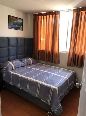 a bedroom with a bed with a blue blanket and a window at 821 Céntrico Departamento en Chorrillos in Lima