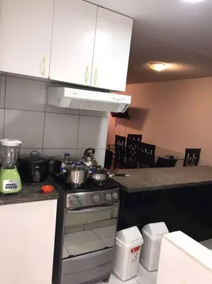 a kitchen with a stove with pots and pans on it at 821 Céntrico Departamento en Chorrillos in Lima