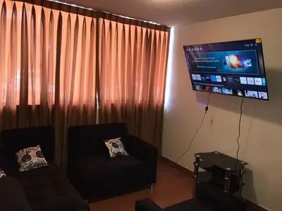a living room with a couch and a flat screen tv at 821 Céntrico Departamento en Chorrillos in Lima