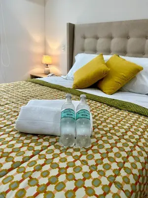 two bottles of water sitting on top of a bed at Moderno Departamento de 2 dormitorios a solo 6 min del Parque Kennedy Miraflores in Lima