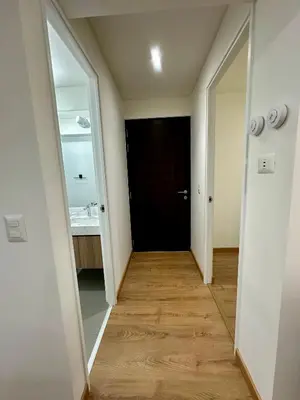 a hallway with a black door and a mirror at Moderno Departamento de 2 dormitorios a solo 6 min del Parque Kennedy Miraflores in Lima