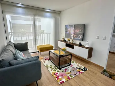 a living room with a couch and a table at Moderno Departamento de 2 dormitorios a solo 6 min del Parque Kennedy Miraflores in Lima