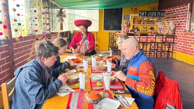a group of people sitting at a table eating food at Sky Dome Peru in Cusco