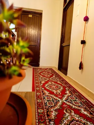 a hallway with a door and a rug on the floor at Hotel Ecoterra Andino Cusco in Cusco