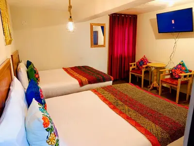 a hotel room with two beds and a tv at Hotel Ecoterra Andino Cusco in Cusco