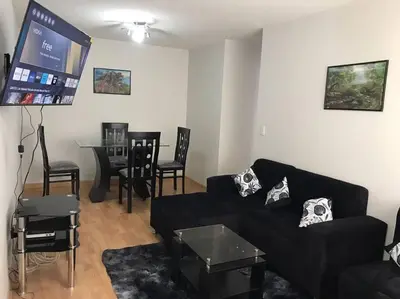 a living room with a black couch and a flat screen tv at 595 Departamento en Chorrillos in Lima