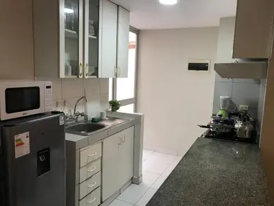 a small kitchen with a sink and a microwave at 595 Departamento en Chorrillos in Lima