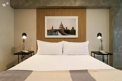 a bedroom with a large white bed with two lamps at Colon by Wynwood House in Lima