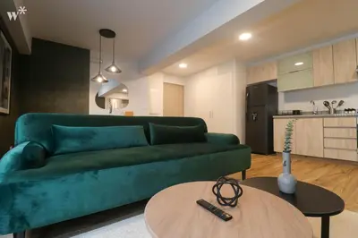 a living room with a green couch and a table at Colon by Wynwood House in Lima