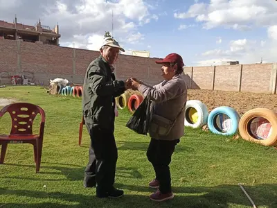 an older man and woman shaking hands in a field at Casa del Virrey Hospedaje in Jauja