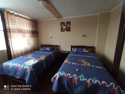 a bedroom with two beds with blue sheets at Casa del Virrey Hospedaje in Jauja