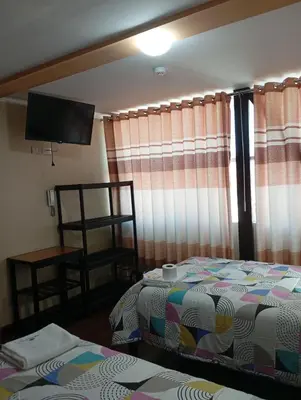 a bedroom with a bed and a flat screen tv at Casa del Virrey Hospedaje in Jauja