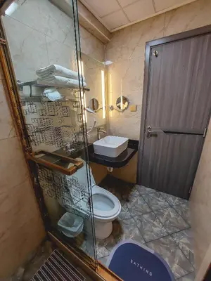 a bathroom with a toilet and a glass shower at Gold Source Hotel in Lima