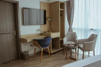 a hotel room with a tv and chairs and a table at Gold Source Hotel in Lima