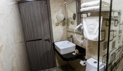 a bathroom with a toilet and a sink and a mirror at Gold Source Hotel in Lima