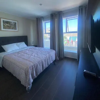 a bedroom with a bed and a large window at Hotel Nebai in Ica