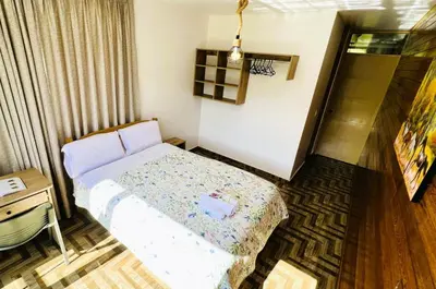 a small bedroom with a bed and a desk at Colina Haus, casa vacacional Oxa in Oxapampa